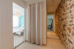 a bedroom with a stone wall and a bed in a room at Haut de VILLA Toulon in Toulon