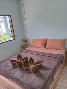 ein Bett mit zwei Kupferschalen darüber in der Unterkunft Baan phuwamin in Ko Lanta