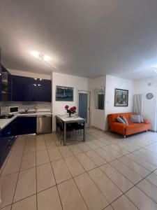 cocina y sala de estar con mesa y sofá en Garden & Pool Perugini, en Nago-Torbole