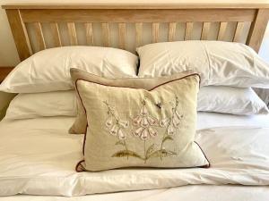 a pillow sitting on top of a bed with pillows at Meadow Cottage in Hampshire's Test Valley in Andover
