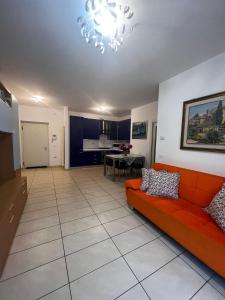 sala de estar con sofá rojo y cocina en Garden & Pool Perugini, en Nago-Torbole