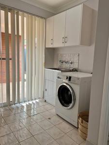 een keuken met een wasmachine in de kamer bij Free secure parking & WiFi in this Executive 3 BR. in Kalgoorlie