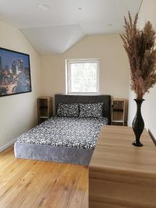 a bedroom with a bed and a vase on a table at Melnrage Beach cozy apartments & terrace - pine view sea entry in Klaipėda