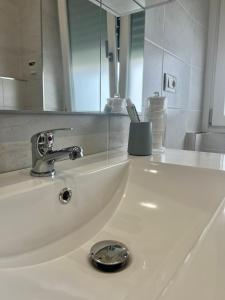lavabo con grifo y espejo en Appartamento La Fenice, en Génova