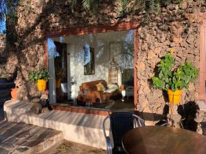 a room with a stone wall with a couch and a table at Apartamento Pirul in Haría