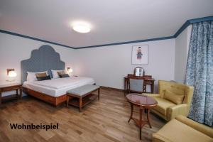 Hotel Goldener Ochs في باد ايشل: غرفة نوم بسرير واريكة وكرسي