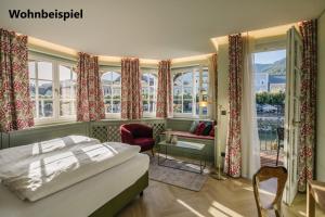 Hotel Goldener Ochs في باد ايشل: غرفة نوم بها سرير وغرفة بها نوافذ