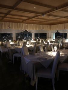 a dining room with white tables and chairs at Naturhotel Wieserhof in Longostagno