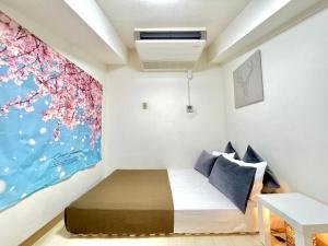 大阪市にあるdotonbori houseのベッドと壁に絵が飾られた寝室