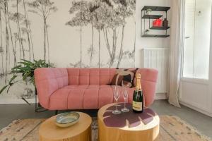 a living room with a pink couch and two tables with wine glasses at L'Authentique ~ Lac 1 km ~ Parking gratuit in Annecy