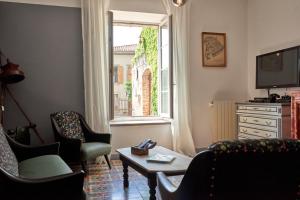 - un salon avec des chaises, une table et une fenêtre dans l'établissement Domaine du Prieuré Couvent & Presbytère, à Carcassonne