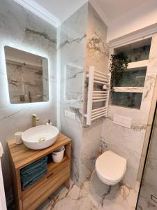 a white bathroom with a sink and a toilet at Luxueux appartement - vue mer - piscine - free parking - Monaco in Cap d'Ail