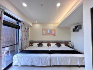 um quarto com uma cama grande e uma janela grande em 花田葉舍 em Tianwei