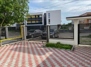 a fence in front of a house with a car at Cozy Apartament with 2Rooms in Timişoara