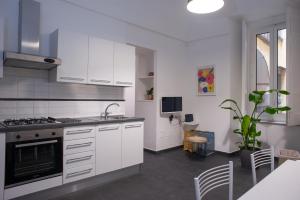 uma cozinha com armários brancos e um fogão em San Liborio bed and breakfast em Nápoles