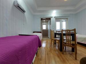 a bedroom with two beds and a table and chairs at Apartment BESO in Kutaisi