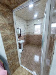 een badkamer met een douche, een toilet en een wastafel bij Apartment BESO in Koetaisi