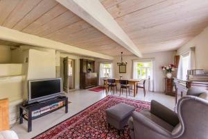 a living room with a television and a dining room at Kuliniai by Stirniai lake Moletai district in Kulintse