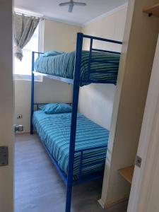 two bunk beds in a room with a window at Acogedor depto al sur de Chile buena accesibilidad in Puerto Montt