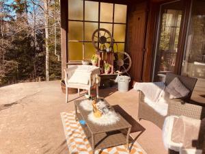 a porch of a house with a table and chairs at un ptit chalet in Les Brenets