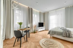 um quarto com uma cama, uma mesa e uma televisão em Villa 44 em Świnoujście
