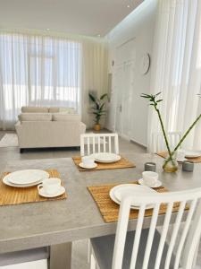 ein Wohnzimmer mit einem Tisch mit Tellern und Stühlen in der Unterkunft غيمة مصفوت 