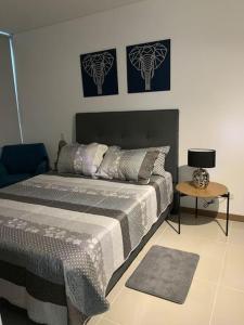 Schlafzimmer mit einem Bett und einem Beistelltisch in der Unterkunft Apartamento ejecutivo la Flora in Cali