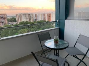 einen Tisch und Stühle auf einem Balkon mit Aussicht in der Unterkunft Apartamento ejecutivo la Flora in Cali