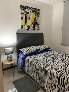 1 dormitorio con cama con estampado de cebra y mesa en Apartamento ejecutivo la Flora, en Cali