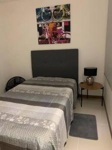 ein Schlafzimmer mit 2 Betten und einem Tisch mit einem Bild in der Unterkunft Apartamento ejecutivo la Flora in Cali
