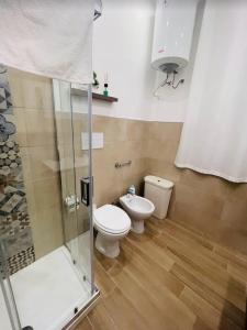a bathroom with a toilet and a glass shower at TRISOLE Palermo in Palermo