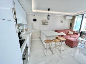 eine Küche und ein Wohnzimmer mit einem Sofa und einem Tisch in der Unterkunft Luxueux appartement - vue mer - piscine - free parking - Monaco in Cap d'Ail
