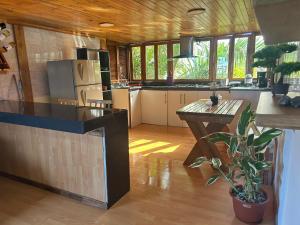 a kitchen with a refrigerator and a table with a plant at Room Papagayo - Ayampe in Ayampe