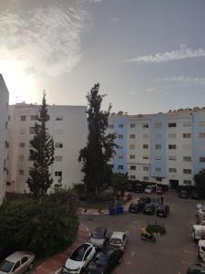 un parking avec des voitures garées devant un bâtiment dans l'établissement Appartement centre-ville agadir, à Agadir