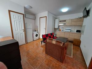a living room with a table and chairs and a kitchen at Apartament un dormitor și living la curte Corbu in Corbu