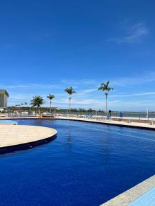 una gran piscina junto a una playa con palmeras en Golden Lake - Vista Lagoa, en Arraial do Cabo