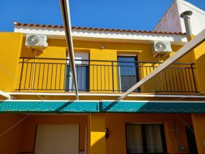 a yellow apartment building with a balcony at Casa Rosangela in Almonacid de Toledo