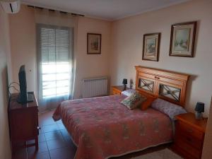 1 dormitorio con 1 cama y TV en Casa Rosangela, en Almonacid de Toledo