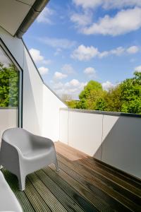 a white chair sitting on the balcony of a house at Louis & Louise Apartments & Lofts Am Wall I Digital Check In in Bremen