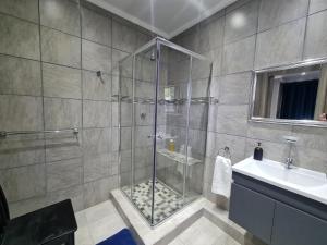 een badkamer met een douche en een wastafel bij Rus 'n Bietjie in Bothaville