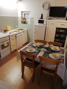 a kitchen with a table and chairs with food on it at Guesthouse Brodarica (3814) in Šibenik +60 photos