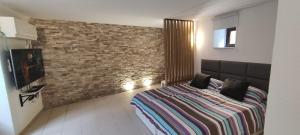 a bedroom with a bed and a brick wall at Apartma Erik Piran in Piran