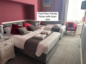 a bedroom with two beds and a first floor family room with town view at Hotel Catania in Scarborough