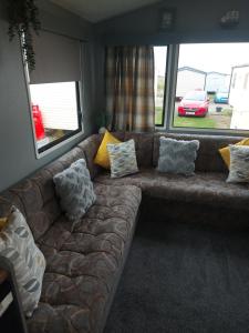 um sofá numa sala de estar com almofadas em Jock's Place em Whitley Bay