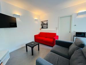- un salon avec un canapé rouge et un fauteuil rouge dans l'établissement Appartamento Magnolia Residenza Prealba, à Levanto