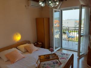 a bedroom with a bed with a table and a balcony at Guesthouse Brodarica (3814) in &Scaron;ibenik