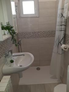 a white bathroom with a sink and a shower at Guesthouse Brodarica (3814) in &Scaron;ibenik
