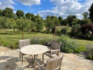 a table and two chairs and a table in a garden at Meadow Cottage in Hampshire's Test Valley in Andover