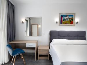 1 dormitorio con cama, silla y espejo en D-Elegant Lapad Dubrovnik, en Dubrovnik