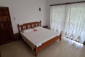 a bedroom with a large bed with white curtains at Island Of Love in Mahe